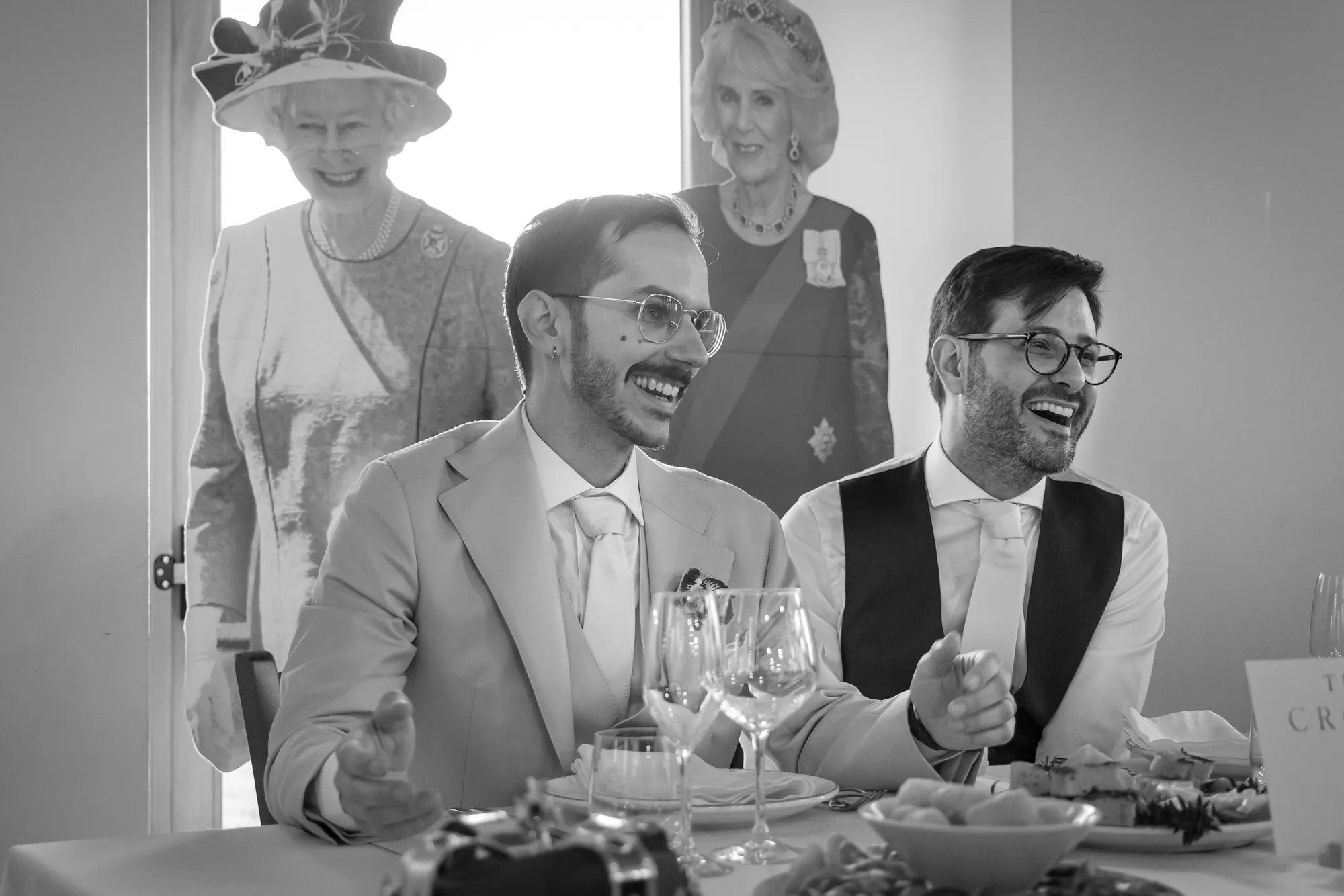 Invitati che ridono a tavola durante una festa di matrimonio